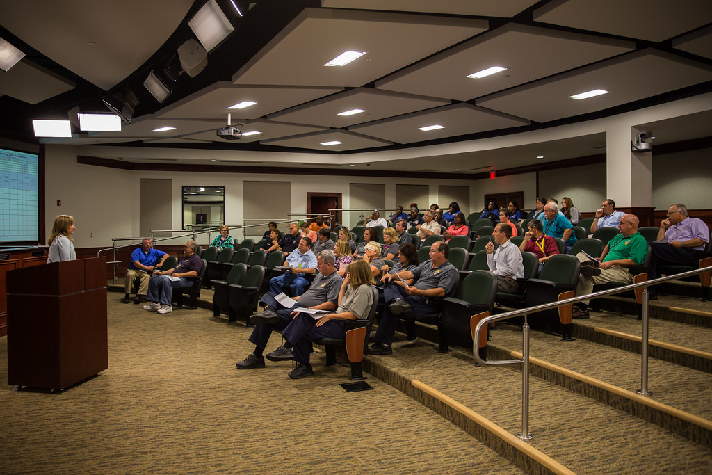 City staff sit in tiered seating while an instructor leads a disaster assessment training session.