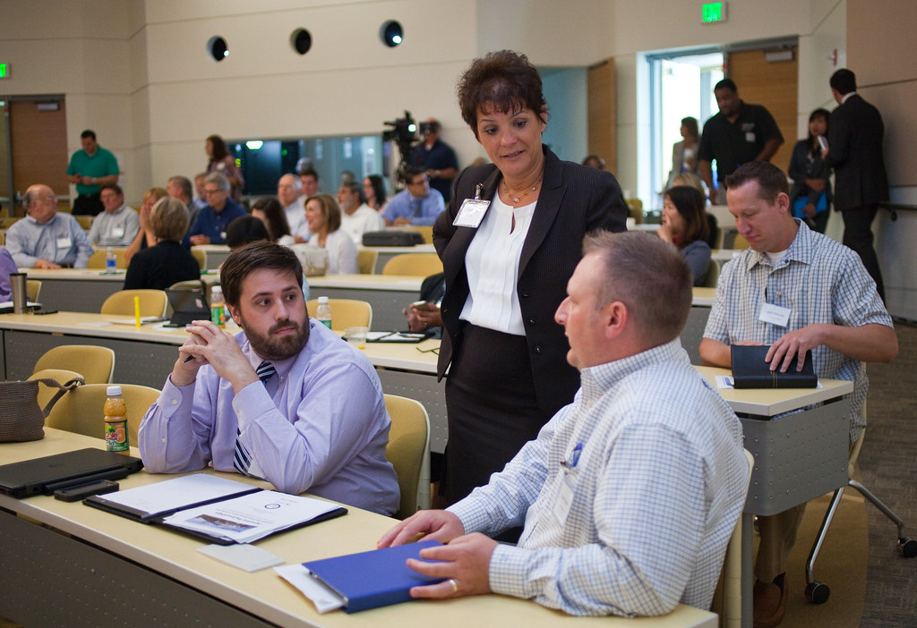 An instructor and workshop participants discuss public and private emergency management partnerships.